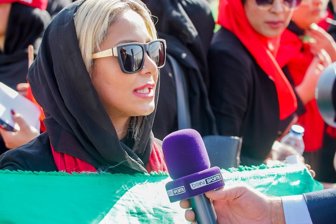 Broadcast journalist speaking into microphone at press conference