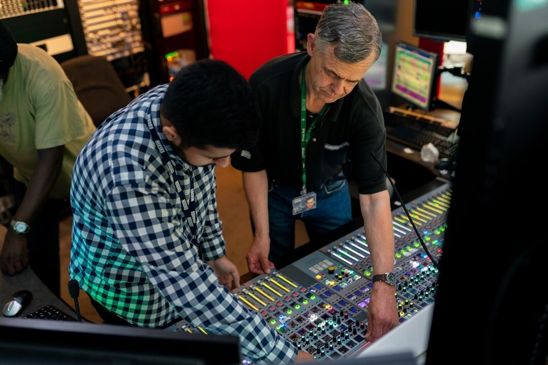 Audio engineer at professional mixing console in broadcast studio
