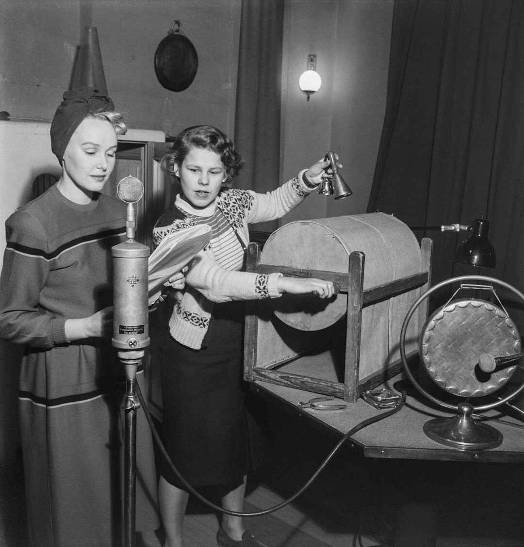 Professional female broadcaster presenting on camera in a modern studio